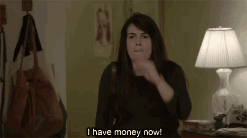a woman is sitting in front of a lamp and says i have money now