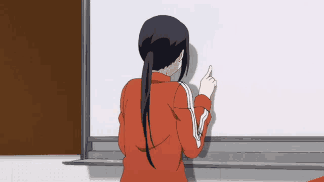 a woman in an orange jacket is pointing at a whiteboard
