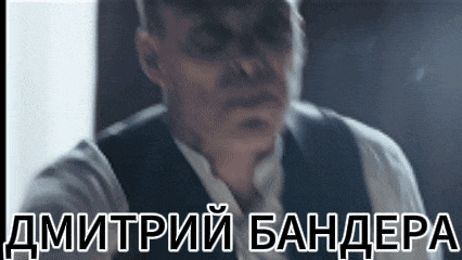 a man in a suit and tie is standing in front of a sign that says dmitry bandepa