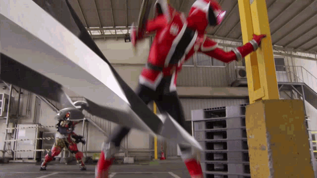 a man in a red and white superhero costume is jumping over a yellow pole