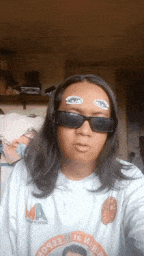 a man wearing sunglasses and a shirt that says ma takes a selfie