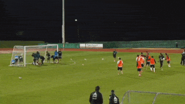 a group of soccer players are practicing on a field with a sign that says ' ruka sport '