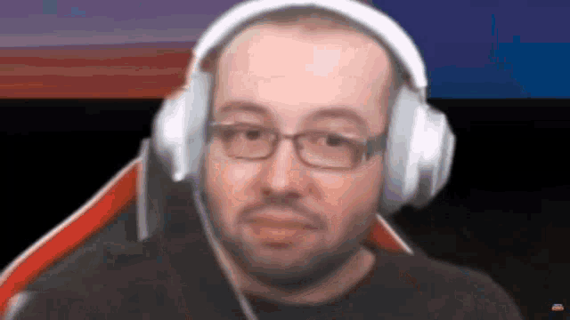 a man with glasses is wearing headphones and a black shirt