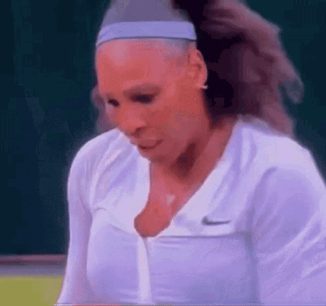 a close up of a woman wearing a headband and a white shirt .