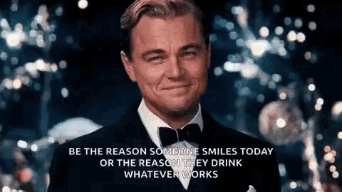 a man in a tuxedo and bow tie is smiling and says be the reason someone smiles today