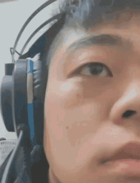 a close up of a person wearing headphones looking at the camera