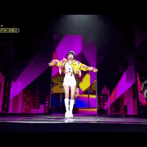 a woman is dancing on a stage with a sign that says miley on it