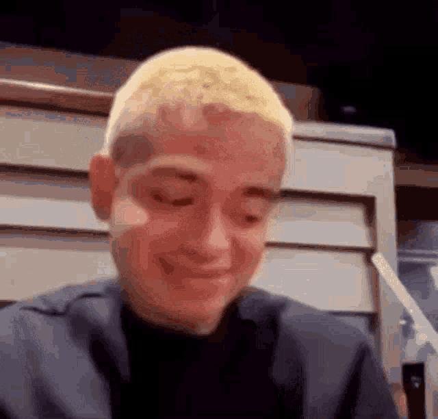 a man with short blonde hair is making a funny face .