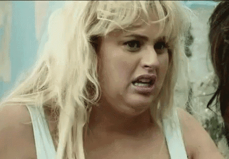 a woman with blonde hair is making a funny face while standing next to another woman .