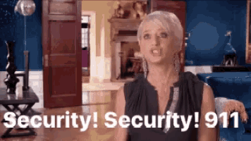 a woman is standing in a living room and saying security ! security ! 911