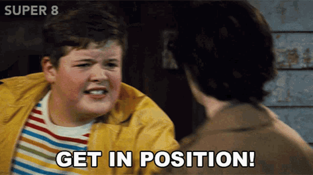 a boy in a yellow jacket says " get in position " to another boy
