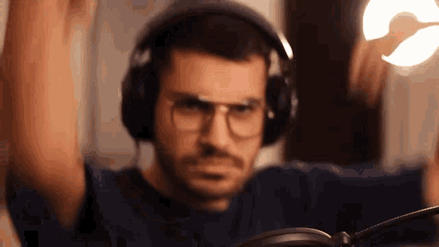 a man wearing headphones and glasses is holding a light in his hand
