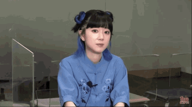 a girl with blue hair is wearing a blue shirt with a microphone on it .