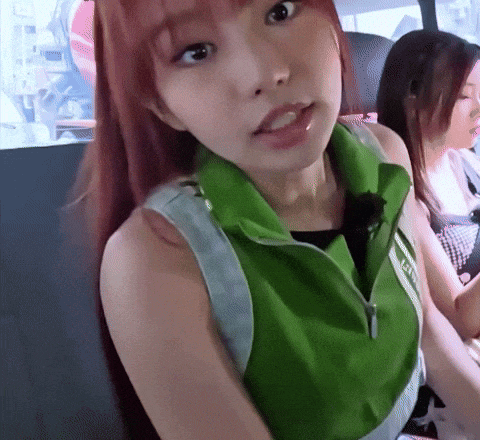 a woman with red hair wearing a green vest that says ' ae ' on it