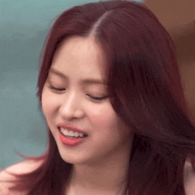 a close up of a woman with red hair smiling .