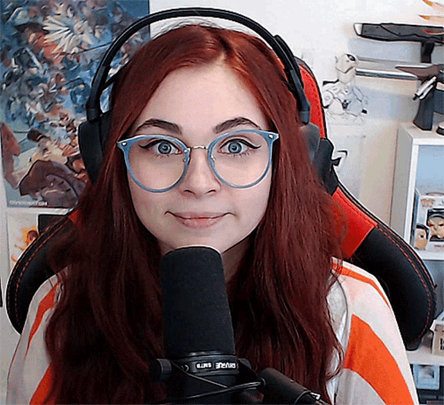 a woman wearing glasses and headphones stands in front of a microphone that says ' sven ' on the front