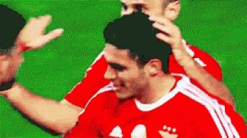 a soccer player in a red and white adidas jersey