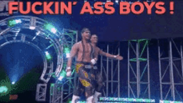 two wrestlers are walking through a tunnel with the words " fuckin ' ass boys " on the bottom