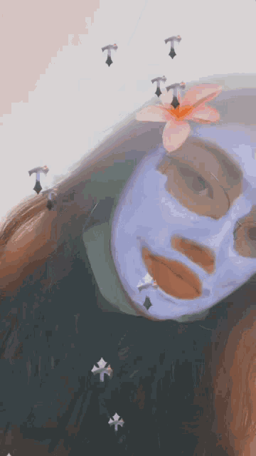 a woman wearing a purple face mask with a pink flower on her head