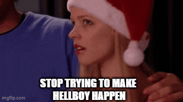 a woman wearing a santa hat is being hugged by a man .