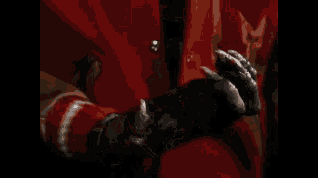 a close up of a person wearing a red coat and a black glove with sharp claws .