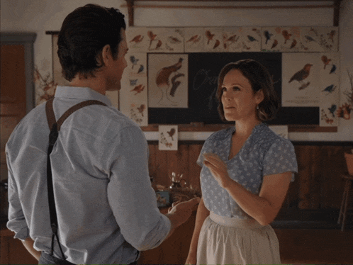 a man and a woman are dancing in front of a blackboard with the word biology on it