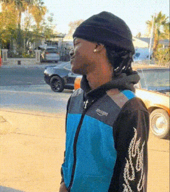 a man wearing a black beanie and a blue jacket that says amazon