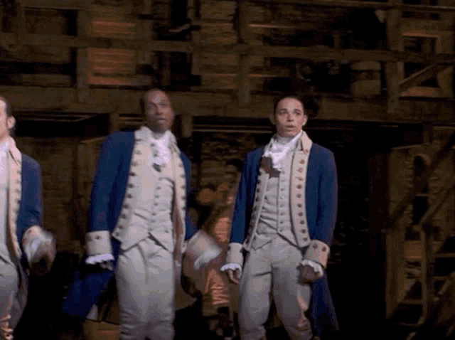 a group of men in military uniforms are standing in a dark room