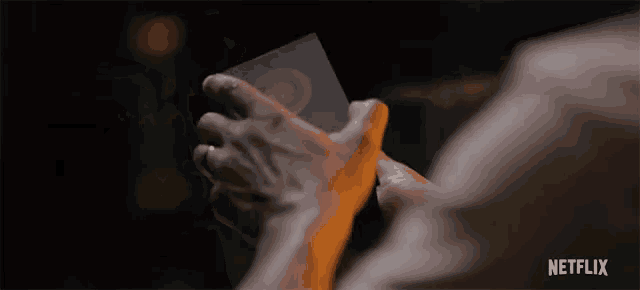 a close up of a person 's hands with a netflix logo in the upper right corner