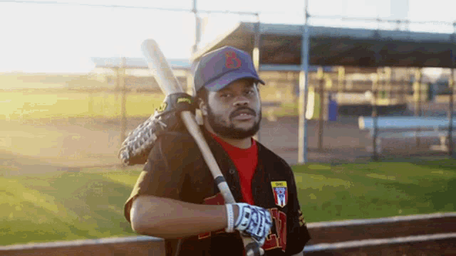a baseball player with the letter b on his hat holds a bat over his shoulder