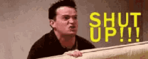 a man is sitting at a piano with the words `` shut up !!! '' written in yellow .