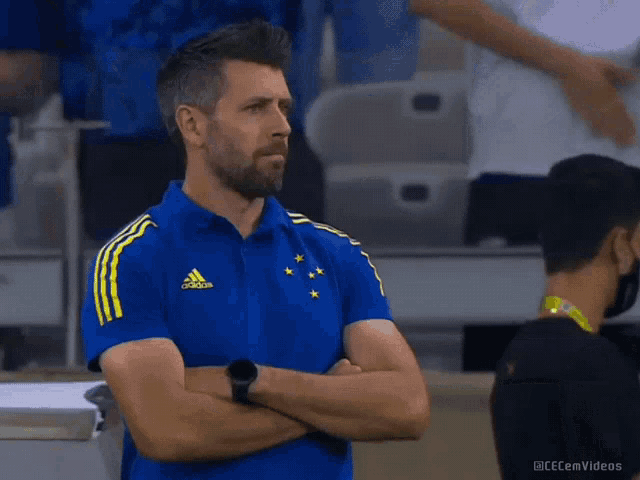 a man wearing a blue and yellow adidas shirt