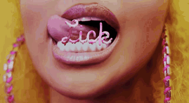 a close up of a woman 's mouth with the word lick on her tongue .