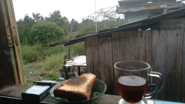 a glass of tea sits on a table next to a plate of toast