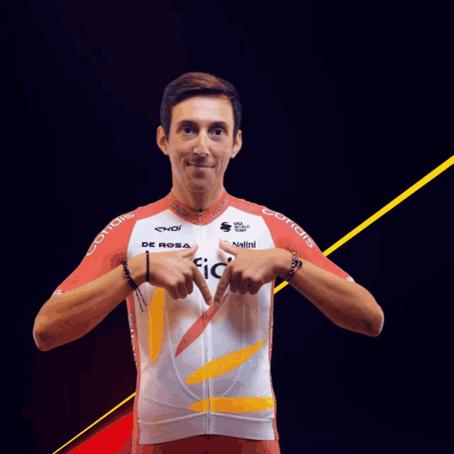 a man wearing a red and white cofidis jersey points at himself