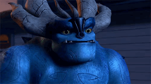 a blue monster with horns and green eyes is looking at the camera