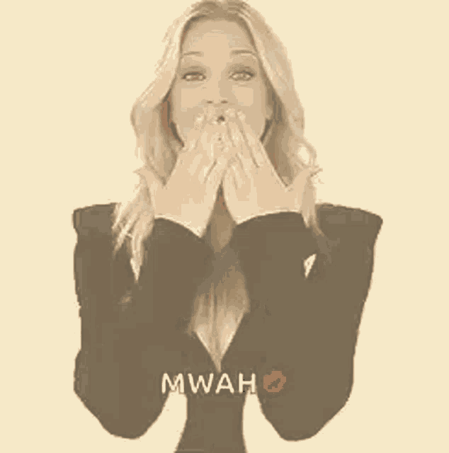 a woman in a black and white dress is giving a kiss and giving a high five .