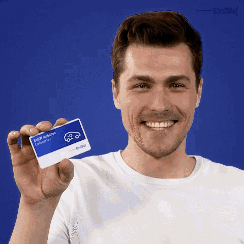 a man in a white shirt is smiling and holding up a card that says e-mobility