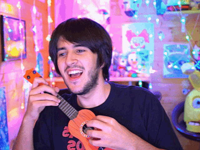 a man in a black shirt with the number 20 on it is playing an orange guitar