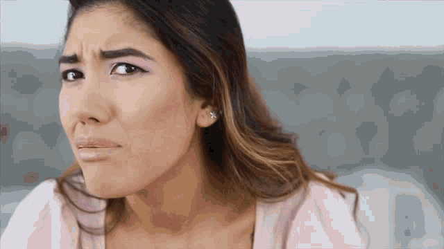 a close up of a woman 's face with a sad look on her face
