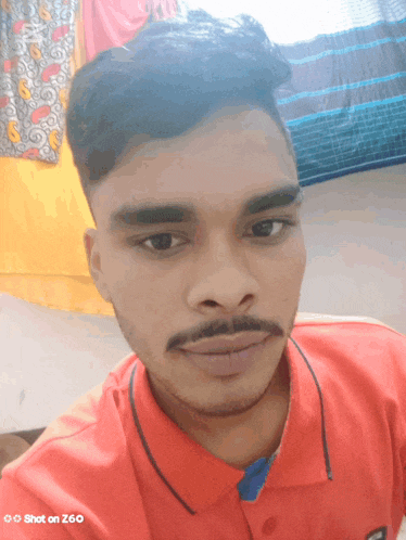 a man with a mustache is taking a selfie with a shot on z60