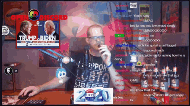 a man is sitting at a desk with a microphone in front of a trump biden sign