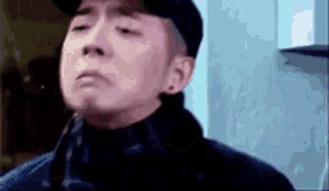 a close up of a man wearing a hat and a jacket .