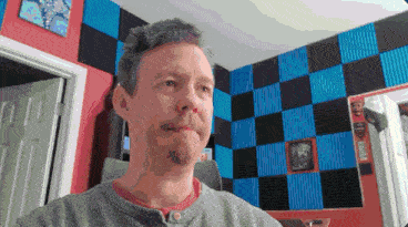 a pixelated image of a man with a beard in a room