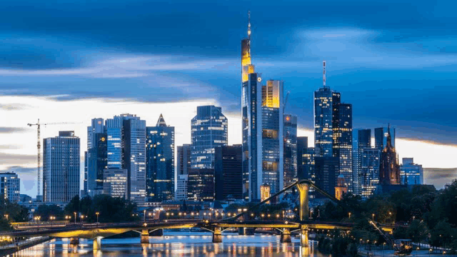 a city skyline with a bridge in the foreground and a river in the background