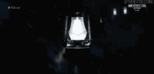 a man is holding a lantern in his hand in the dark