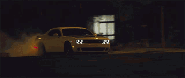 a dodge challenger driving down a street at night