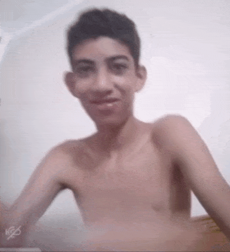 a shirtless boy is smiling and looking at the camera .