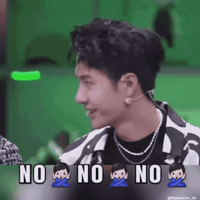 a man is sitting in front of a green screen with the words no no no written on it .