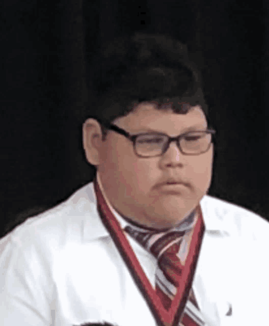 a young boy wearing glasses and a medal around his neck
